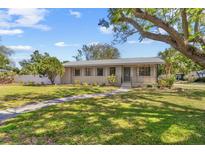 Charming single-story home featuring a well-manicured lawn, lovely landscaping, and a welcoming walkway at 300 22Nd S Ave, St Petersburg, FL 33705