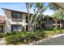 Inviting condo featuring mature trees, two-story design, and well-maintained landscaping at 3600 Magnolia Ridge Cir # 1221-G, Palm Harbor, FL 34684