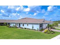 Charming single-story home with lush green lawn and well-manicured landscaping under a bright blue sky at 3765 Maxwell Park Dr, Sun City Center, FL 33573