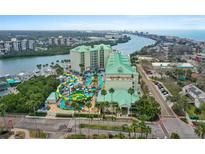 Hotel exterior featuring a waterpark with colorful slides, lazy river, and lush landscaping with palm trees at 399 C 2Nd St # 313, Indian Rocks Beach, FL 33785