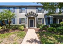 Charming townhome featuring a landscaped yard with a paver walkway, inviting curb appeal, and a covered entryway at 4183 Ballantrae Blvd, Land O Lakes, FL 34638
