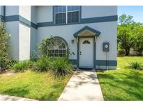 Charming townhome featuring a white front door with a portico and manicured front lawn at 605 Bainbridge Dr, Brandon, FL 33511