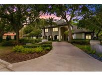Stunning home exterior featuring a large driveway, lush landscaping, and architectural design at 6352 W Maclaurin Dr, Tampa, FL 33647