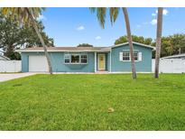 Charming blue single-story home with a green lawn and inviting yellow door at 7690 91St St, Seminole, FL 33777