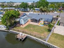 Aerial of backyard with dock, screened lanai, gazebo and shed on canal in Bay Crest Park at 8702 Driftwood Dr, Tampa, FL 33615