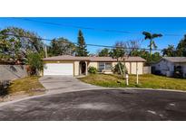 Cozy single-story home featuring a convenient attached garage and a well-maintained front lawn at 920 Palm Dr, Belleair Beach, FL 33786
