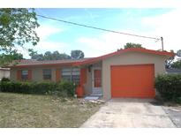 Charming single-story home featuring a well-manicured front yard and a one-car garage with an orange door at 1146 Alma St, Clearwater, FL 33756