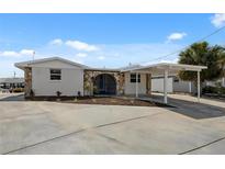 Charming single-story home with a stone entryway and a covered parking area at 13810 Malcolm Ave, Hudson, FL 34667