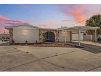 Charming single-story home boasting unique stone accents, a covered carport, and a spacious driveway at 13810 Malcolm Ave, Hudson, FL 34667