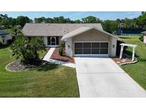 Charming single-story home with well-manicured lawn, mature palm trees, and a screened two-car garage at 3276 Hilary Cir, Palm Harbor, FL 34684