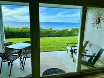 Enjoy beautiful ocean views from the patio with seating and a table, perfect for relaxing or entertaining at 3400 Gulf Blvd # 102, Belleair Beach, FL 33786