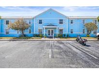 Inviting condo complex featuring charming blue facade, well-maintained landscaping and ample parking at 5003 Starfish Dr Se # B, St Petersburg, FL 33705