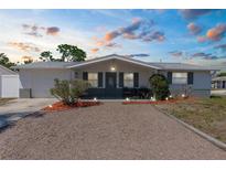 Charming single-story home with a well-maintained gravel front yard and inviting exterior lighting at 5117 Fitchburg Dr, Holiday, FL 34690