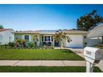 Charming single-story home featuring lush landscaping, a well-manicured lawn, and a welcoming front entrance at 12901 129Th Ave, Largo, FL 33774