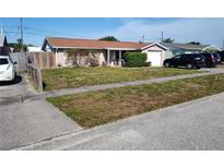 Charming single-story home featuring a well-manicured lawn, cozy porch, and an attached garage, perfect for suburban living at 1155 Royalwood Dr, Holiday, FL 34690