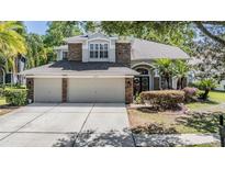 Charming two-story home features stone accents and a spacious three-car garage, nestled in a lush, green neighborhood at 12712 Stanwyck Cir, Tampa, FL 33626