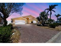Beautifully landscaped home featuring a brick driveway and lush tropical greenery at 17 Bellevue Dr, Treasure Island, FL 33706