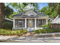 Charming home with a welcoming front porch and inviting curb appeal surrounded by lush greenery at 2810 N Jefferson St, Tampa, FL 33602