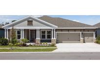 Beautiful home with a three car garage, elegant landscaping, and a cozy front porch at 5152 Wildwind Dr, Apollo Beach, FL 33572