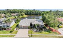 A charming home with a tile roof is situated on a lush, green lot near a tranquil lake, offering beautiful curb appeal at 1307 Forestedge Blvd, Oldsmar, FL 34677