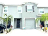 Modern townhome featuring a one-car garage, a neutral color scheme, and simple landscaping at 1490 Colt Creek Pl, Wesley Chapel, FL 33543