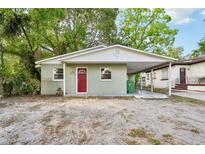 Charming single-story home with a carport, fresh paint, and a vibrant red door at 1720 W Arch St, Tampa, FL 33607