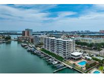 Waterfront condo complex featuring boat docks, swimming pool, and views of the city skyline at 223 Island Way # 5D, Clearwater Beach, FL 33767
