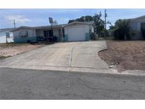 Modest one-story home featuring an attached garage, a front yard, and a basketball hoop at 4920 Zodiac Ave, Holiday, FL 34690