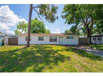 Charming single-story home with a well-maintained front lawn and mature trees providing ample shade at 5119 Gateway Dr, Tampa, FL 33615