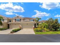 Beautiful townhome featuring an attached two-car garage, manicured landscaping, and tile roof at 582 53Rd N Ave, St Petersburg, FL 33703