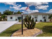 Charming single-story home featuring well-manicured landscaping and an American flag waving proudly at 603 Fort Duquesna Dr, Sun City Center, FL 33573