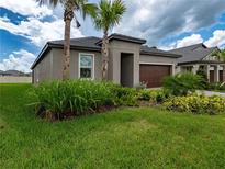 Well-maintained single-story home featuring a manicured lawn and tidy landscaping at 10446 Tupper Cay Dr, San Antonio, FL 33576
