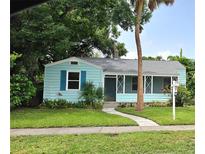 Charming light blue home with green lawn, walkway and mature landscaping at 1069 21St N Ave, St Petersburg, FL 33704
