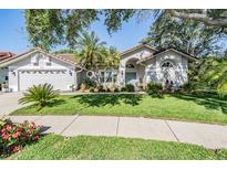 Charming single-story home featuring a well-manicured lawn, mature landscaping, and a two-car garage at 1119 Hounds Run, Safety Harbor, FL 34695