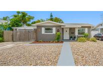 Charming single-story home with gray exterior, white trim, stone landscaping, and a welcoming front door at 1120 45Th N St, St Petersburg, FL 33713