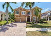 Stunning two-story home featuring lush landscaping, a paver driveway, and a two-car garage at 12817 Darby Ridge Dr, Tampa, FL 33624