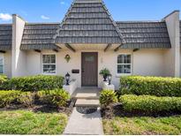 Charming front exterior featuring well-maintained landscaping and a unique roofline at 1702 Cordova Green, Seminole, FL 33777