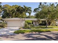Charming single-story home boasts lush landscaping, a well-maintained lawn, and a two-car garage at 301 62Nd S Ave, St Petersburg, FL 33705