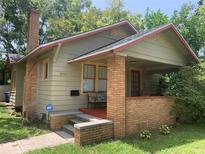 Charming bungalow featuring a brick front porch, tan siding, and a brick chimney at 3100 11Th N Ave, St Petersburg, FL 33713