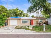 Charming single-story home featuring a well-maintained yard, neutral paint, and a striking red front door at 6627 Main St, New Port Richey, FL 34653
