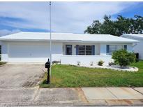 Charming single-story home with a well-manicured lawn and a classic white exterior at 9035 37Th N St, Pinellas Park, FL 33782
