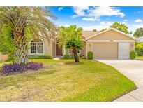 Charming single-story home with well-manicured lawn, lush landscaping, and a two-car garage at 11284 Hickory Ridge Ct, Spring Hill, FL 34609