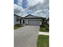 Beautiful single-story home with gray garage doors, tile roof, and landscaped front yard at 17122 Moonflower Dr, Venice, FL 34293