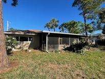 Charming single-story home featuring a screened lanai and lush landscaping at 5365 Dover Ne St, St Petersburg, FL 33703