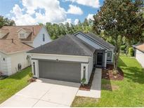 Charming single-story home features a well-manicured lawn, a gray roof and a gray two-car garage at 6116 Skylarkcrest Dr, Lithia, FL 33547
