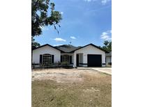 Charming single-story home with black trim, a well-maintained lawn, and a two-car garage at 613 Coronet St, Plant City, FL 33563
