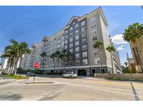 Beautiful multi-story condo building in gray and white, enhanced by palm trees, under a bright blue sky at 700 S Harbour Island Blvd # 740, Tampa, FL 33602
