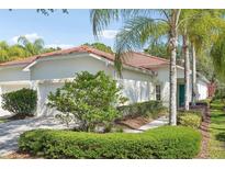 Charming home features a red tile roof, lush landscaping, and a quaint, inviting entrance at 10260 Devonshire Lake Dr, Tampa, FL 33647