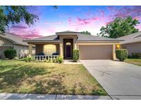 Charming single-story home with a well-manicured lawn, inviting front porch, and two-car garage at 1406 Bloomingdale Trails Blvd, Brandon, FL 33511