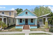 Charming light blue two-story home with a welcoming front porch and colorful accents at 1708 E 15Th Ave, Tampa, FL 33605